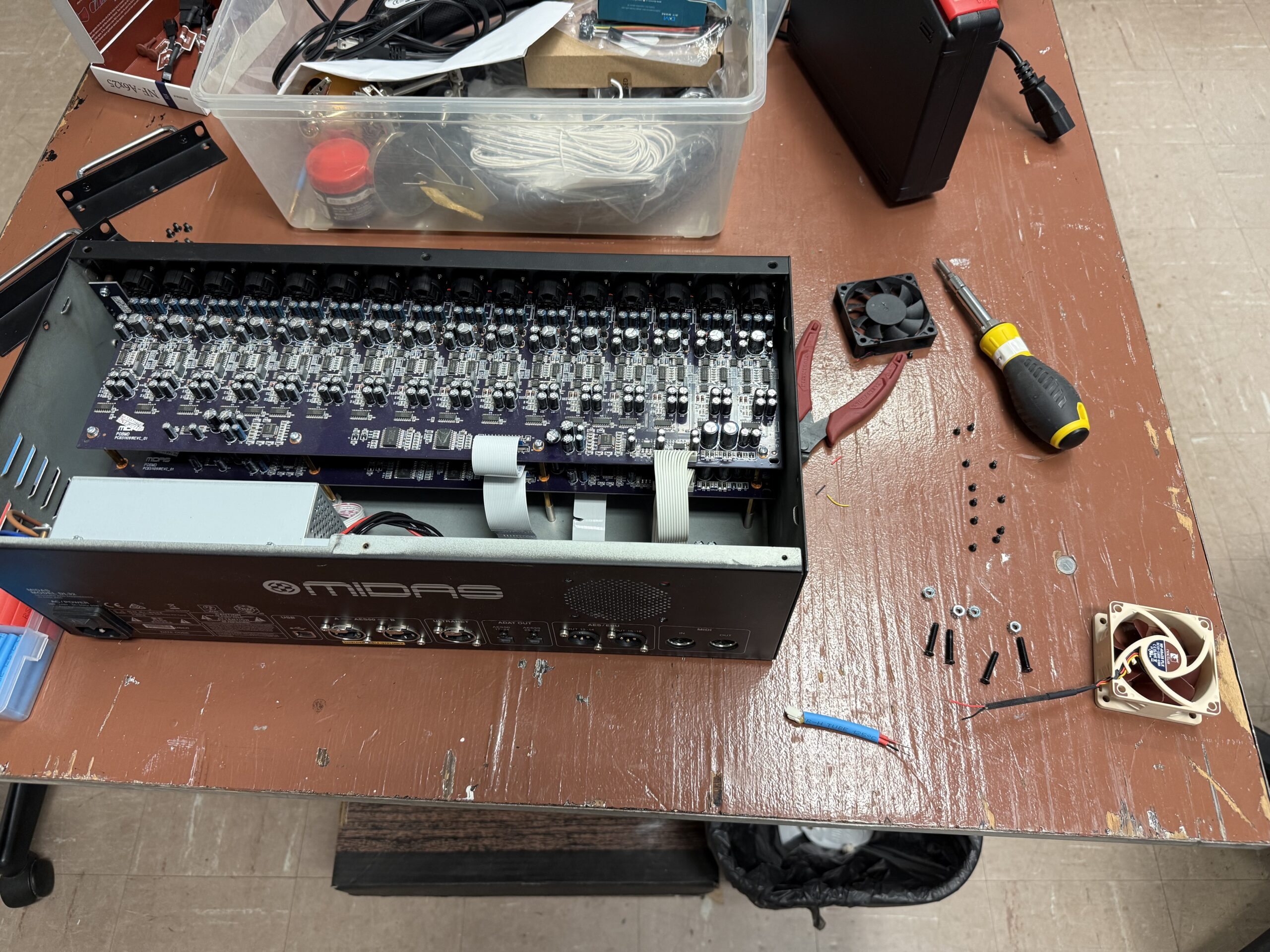 Midas DL32 open on workbench with old fan removed and Noctua fan unboxed